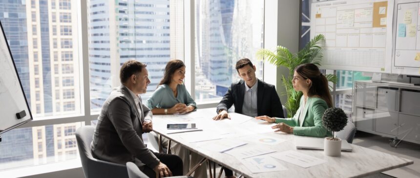 Business,Team,Talking,At,Table,In,Meeting,Room,,Discussing,Job