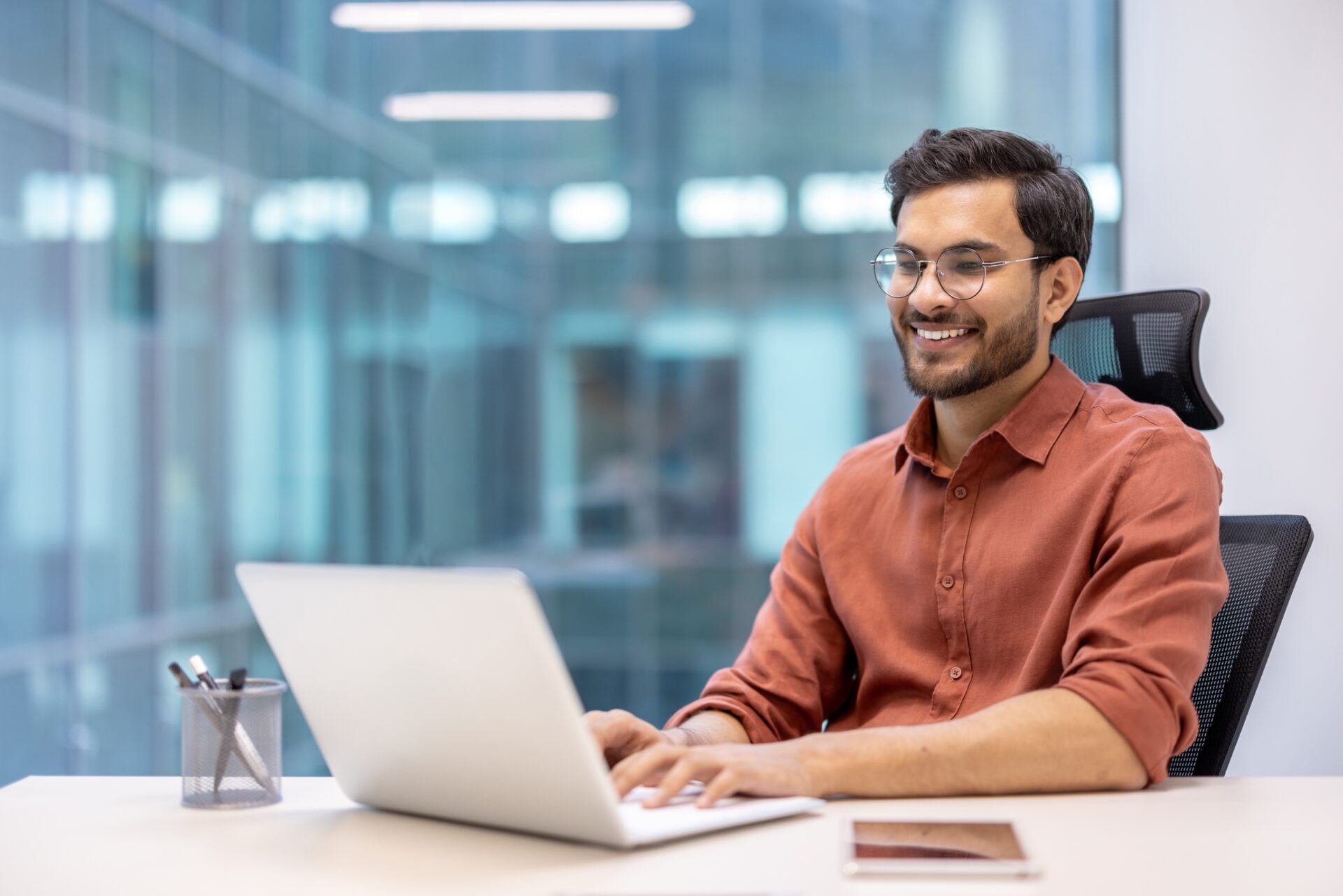 Confident,Man,In,Casual,Attire,Working,On,Laptop,At,Office