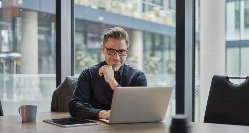 Businessman,Using,Laptop,Computer,In,Office.,Happy,Middle,Aged,Man,