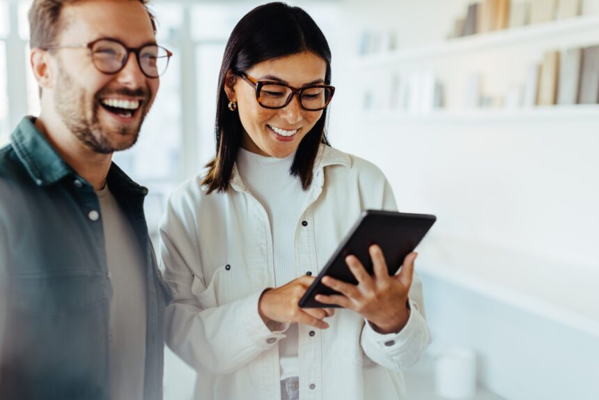 Female,Designer,Standing,With,Her,Colleague,And,Using,A,Tablet.