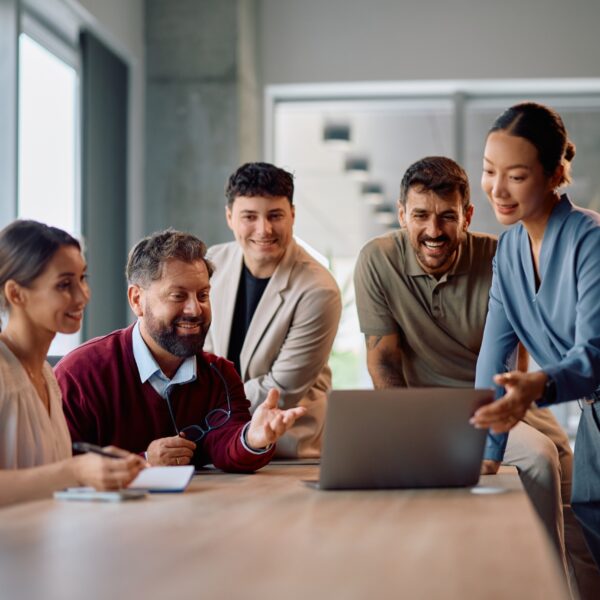 Multiracial,Group,Of,Entrepreneurs,Working,On,Laptop,During,Business,Meeting